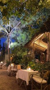 南威阿提花园酒店的一间设有桌椅的餐厅,并种植了棕榈树