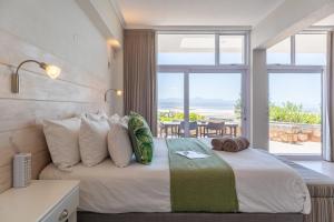 普利登堡湾Lookout Lodge的一间卧室设有一张床,享有海景