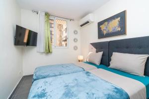 帕皮提HEITEA LODGE - 6 min airport, Wifi, AC & Parking的卧室配有蓝色和白色的床和电视。