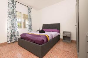 BonanzaDulce Carmen的一间卧室配有一张带紫色床单的大床