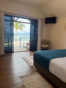 苏梅岛Le Shelby Samui Beach Resort Cottage的一间卧室配有一张床,享有海景