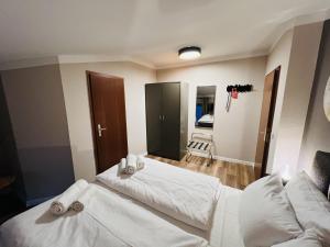 黑灵斯多夫Hotel Garni BALTICpetite的一间卧室配有两张带白色床单的床