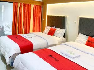 日惹RedDoorz near Museum Gunung Merapi的红色和白色的酒店客房内的两张床