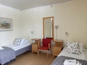 基律纳STF玛丽丰滕斯福利斯科拉酒店的一间设有两张床、椅子和镜子的房间