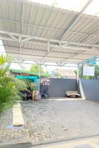 明古鲁省Pondokan Guest House Rinjani Syariah的白色屋顶下带长凳的亭子