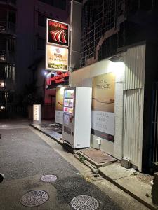 神户ホテル トランス 男塾ホテルグループ的两个冰箱在晚上在建筑物的一侧