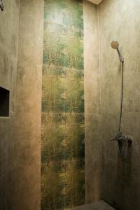 尼兹瓦Nima guest house的淋浴间配有绿色和金色壁纸