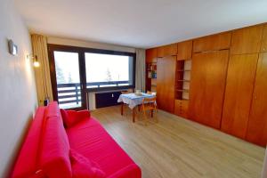 摩德纳迪-坎皮格里奥Carlo Magno Studio apartment的客厅配有红色的沙发和桌子