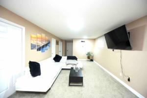 金斯顿Adorable Spacious Inn with Indoor fireplace的客厅配有白色沙发和平面电视。