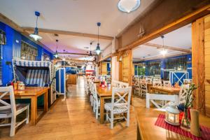 加茨比亚格拉Papaj Resort的配有木桌和椅子的餐厅