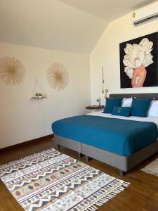 苏梅岛Le Shelby Samui Beach Resort Cottage的一间卧室配有蓝色的床和地毯