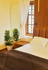 阿勒皮SHORE STORIES的一间卧室配有一张床和一个植物窗户