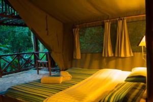 KyenjojoKibale Forest Camp by NATURE LODGES LTD的帐篷内一间卧室,配有一张床