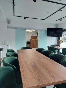 博尔沙Pensiunea Cascada的一间会议室,配有木桌和绿色椅子