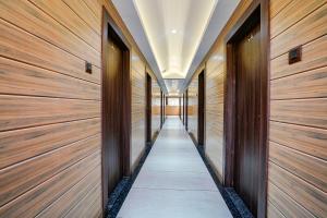 纳威孟买FabHotel Grand Inn I的走廊上设有木墙,走廊上设有木门
