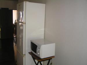 富良野青年之家膳食公寓的冰箱旁的微波炉