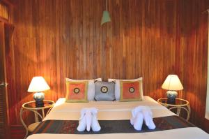 湄南海滩罗望子旅舍的一间卧室配有一张床,并备有2个拖鞋