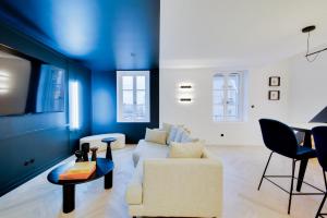 南希Le Splendide de Poincaré的客厅配有白色沙发和蓝色的墙壁