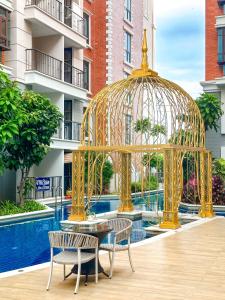 乔木提恩海滩Espana Resort Jomtien Beach Pattaya的一个带两把椅子和一张桌子的金色凉亭