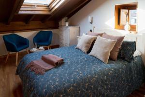 圣地亚哥－德孔波斯特拉Hostal Pension Artilleiro的一间卧室配有一张大床,提供蓝色的床单和枕头