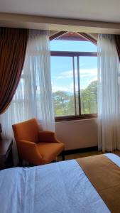 碧瑶Unit 551,Privately Owned, Superior Room At the Forest Lodge Camp John Hay, Mountain View, 2 Double Beds的一间卧室配有椅子和大窗户