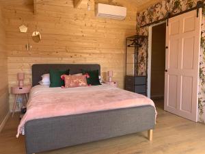 惠茨特布尔Bijou Bunker的一间卧室设有一张床和木墙
