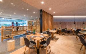 坎波迪特伦斯里乐酒店的餐厅设有木桌、椅子和大窗户。