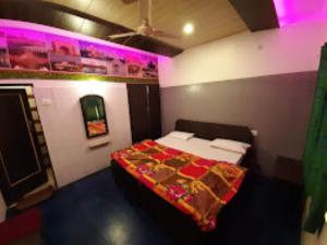 阿格拉HOTEL TAJ DELUXE, Agra的紫色灯室里一间卧室,配有一张床