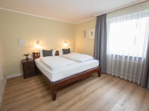 慕尼黑Hotel Altmünchen by Blattl的一间卧室设有一张床和一个大窗户