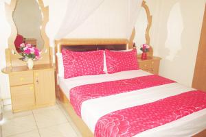 贾夫纳Nallur Mylooran Arangam的一间卧室配有一张带粉色床单和枕头的床。