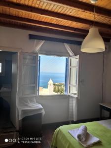 圣斯特凡诺斯Mykonos Rooms的一间卧室设有海景窗户