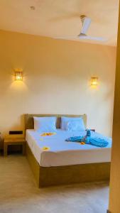 迪克韦勒Ayubowan Hiriketiya的一间卧室配有一张带蓝色床单和枕头的床。