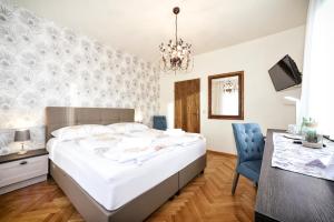 巴特塔茨曼斯多夫贝德塔茨曼斯得福马尔蒂尼霍夫酒店的卧室配有一张白色大床和一张书桌