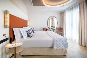 格拉纳达巴塞罗卡门格拉纳达酒店的卧室配有一张白色大床和镜子