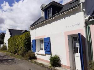 勒帕莱ty anna maison de pêcheur的白色的建筑,在街上有蓝色百叶窗