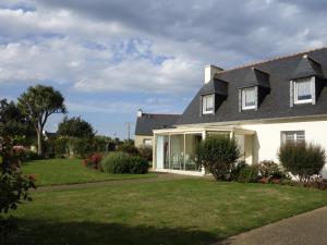 LanmodezMaison de la Presqu'île - 4 chambres avec Vue Mer的白色的房子,有草地和鲜花的院子
