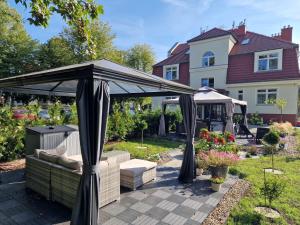 斯维诺乌伊希切Villa Babette - Ubernachtung, Parkplatz, Kurtaxe, Wifi, Aufraumung - Alles im Preis!的房屋后院的凉亭