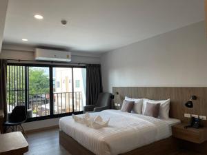 Ban Na KhamNakara Hotel, Ubon Ratchathani的一间带大床的卧室和一个阳台