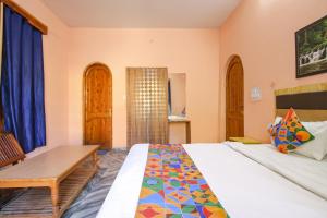 库尔卢FabExpress Malti Guest House的一间卧室配有一张床和一张木桌