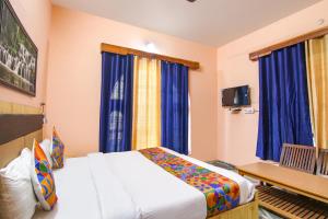 库尔卢FabExpress Malti Guest House的一间卧室配有床和蓝色窗帘