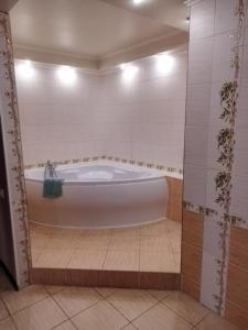 基辅SunLake Hotel Osokorki的浴室铺有白色瓷砖,配有浴缸。