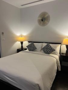 卡塔海滩卡塔花园公寓的卧室配有白色床、两盏灯和闹钟