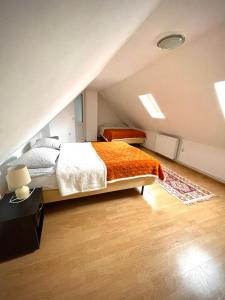 PietroasaLa Mama的阁楼卧室配有带橙色毯子的床