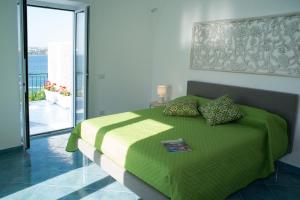 普罗奇达Punta Lingua Relais - Room 2 Sunset Terrace的一间卧室设有一张绿色的床和一个阳台