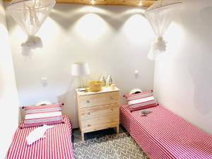 圣罗克杜皮库WAKA PICO AZORES的配有红色和白色床单的客房内的两张床