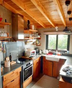 圣罗克杜皮库WAKA PICO AZORES的一个带木制橱柜和大窗户的厨房