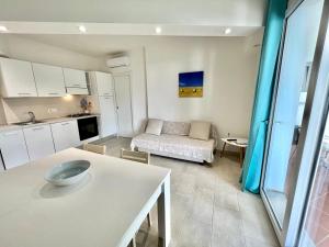 皮诺港Angolo Mare Apartments & Rooms的厨房以及带沙发的起居室。