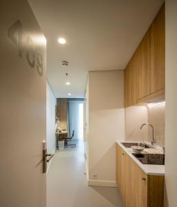 波尔图micampus Porto Tower的厨房设有白色的墙壁和木制橱柜。