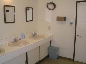 富良野青年之家膳食公寓的浴室设有2个水槽和2面镜子