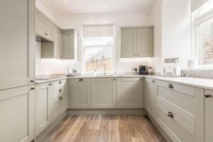 金斯巴恩斯Daisybank Kingsbarns - Beautiful 3 Bedroom Cottage的厨房配有白色橱柜和窗户。
